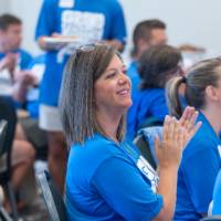 Woman clapping, looking at speaker